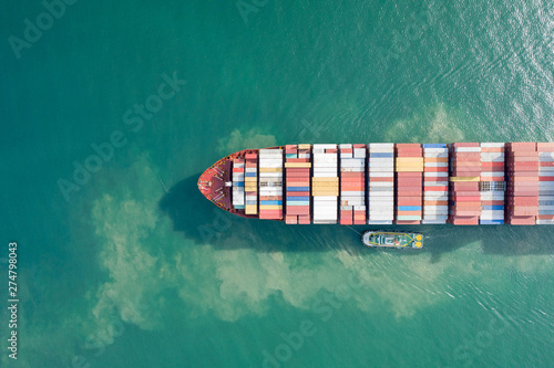 Aerial view and top view. Container ship in pier with crane bridge carries out export  and import business in the open sea. Logistics and transportation