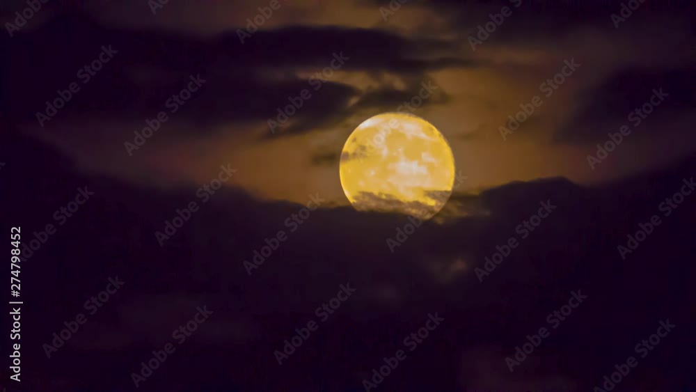 The full moon in the night sky rises because of clouds The full moon in the night sky rises because of clouds
