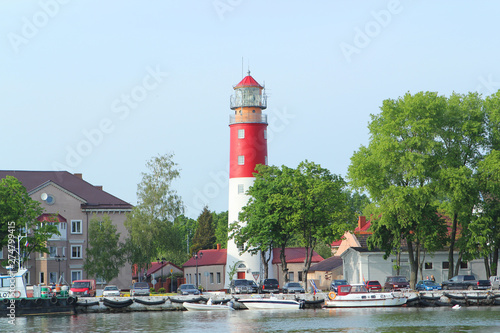 Baltiysk, RUSSIA, MAY 2016: the Baltic Sea coast in the town of Baltiysk with a beautiful old lighthouse and ships at the pier