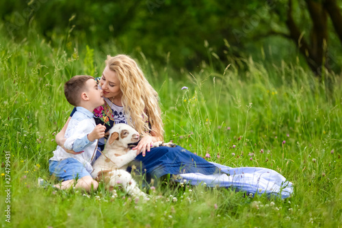 Caucasian Mother with Her Little Son and Cub of Newborn Lamb Posing Outdoors on Nature Background. photo