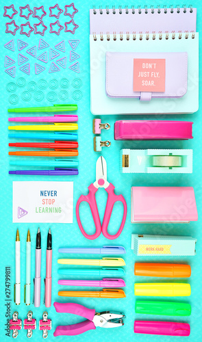 Back to school or workspace colorful stationery on aqua blue background, overhead flat lay.