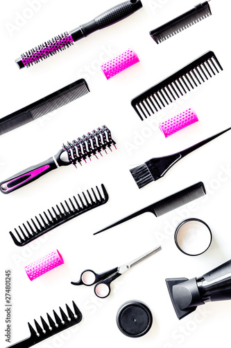 professional pink accessories of hairdresser with combs and sciccors on work desk white background top view pattern