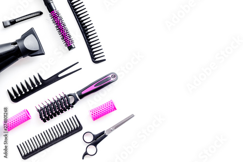 Fototapeta Naklejka Na Ścianę i Meble -  Combs, sciccors and pink hairdresser tools in beauty salon work desk on white background top view mockup