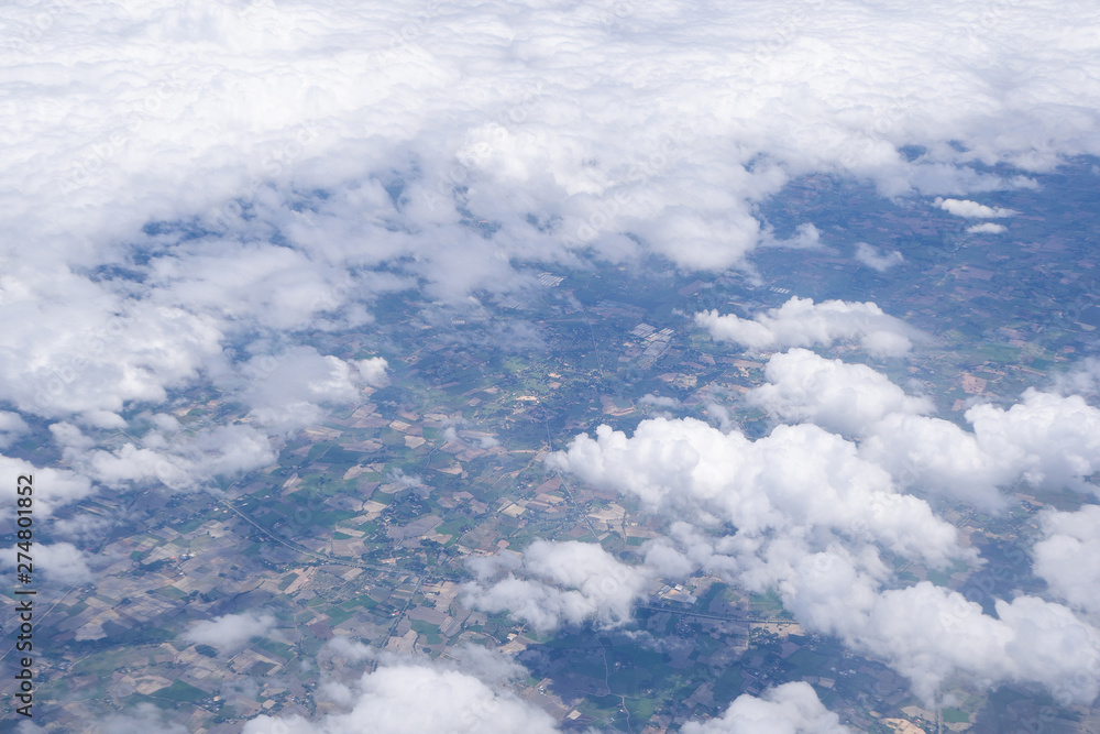 Beautiful scenery of sky, white clouds and land looking from window on airplane Beautiful scenery of sky, white clouds and land looking from window on airplane