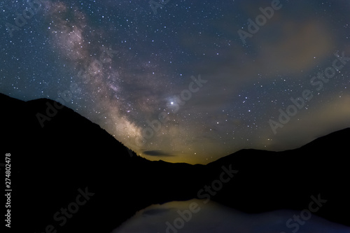 smoke from wildfire and milky way reflecting over a lake in washington usa