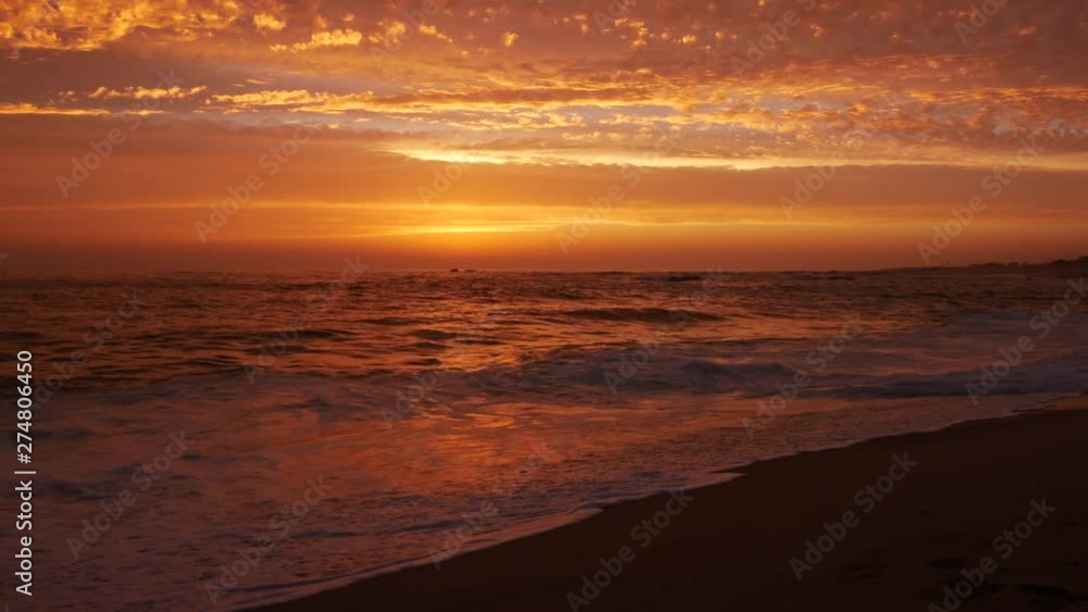 Low angle shot at dusk on beach with beautiful orange sky Low angle shot at dusk on beach with beautiful orange sky