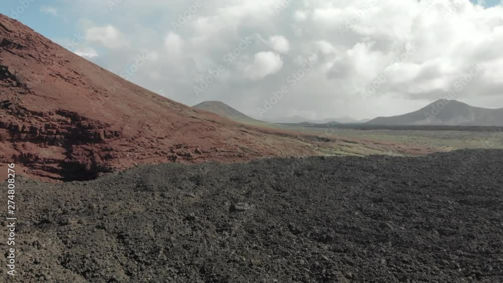 Flying near the ground next to a red mountain, with a cloud and sun sky Flying near the ground next to a red mountain, with a cloud and sun sky