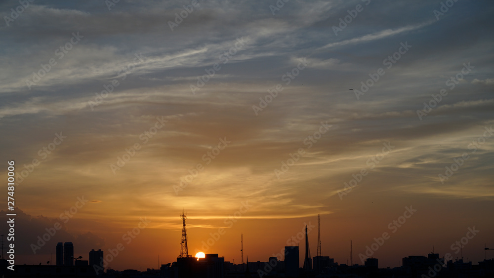 Sunset at horizon with building silhouette in foreground, Bangkok, Thailand