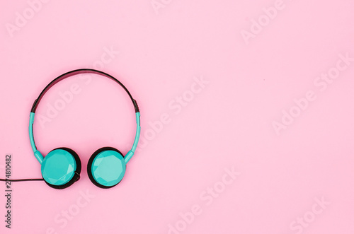 Top view image of headphones and earphones on pink pastel background. Retro style, minimalism. Flat lay. .