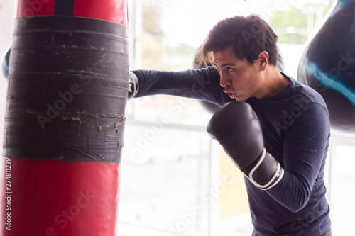 hombre entrenando con guantes sacos de entrenamiento en gimnasio entrenador © Gener Vázquez