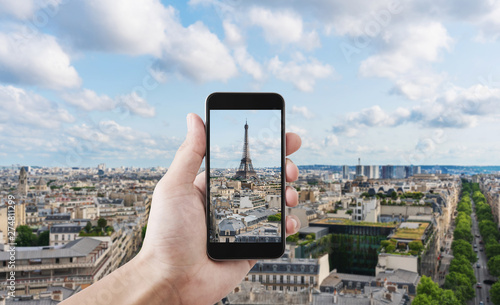 Hand taking photo of Eiffel tower, famous landmark and travel destination in Paris, France by mobile smart phone photo