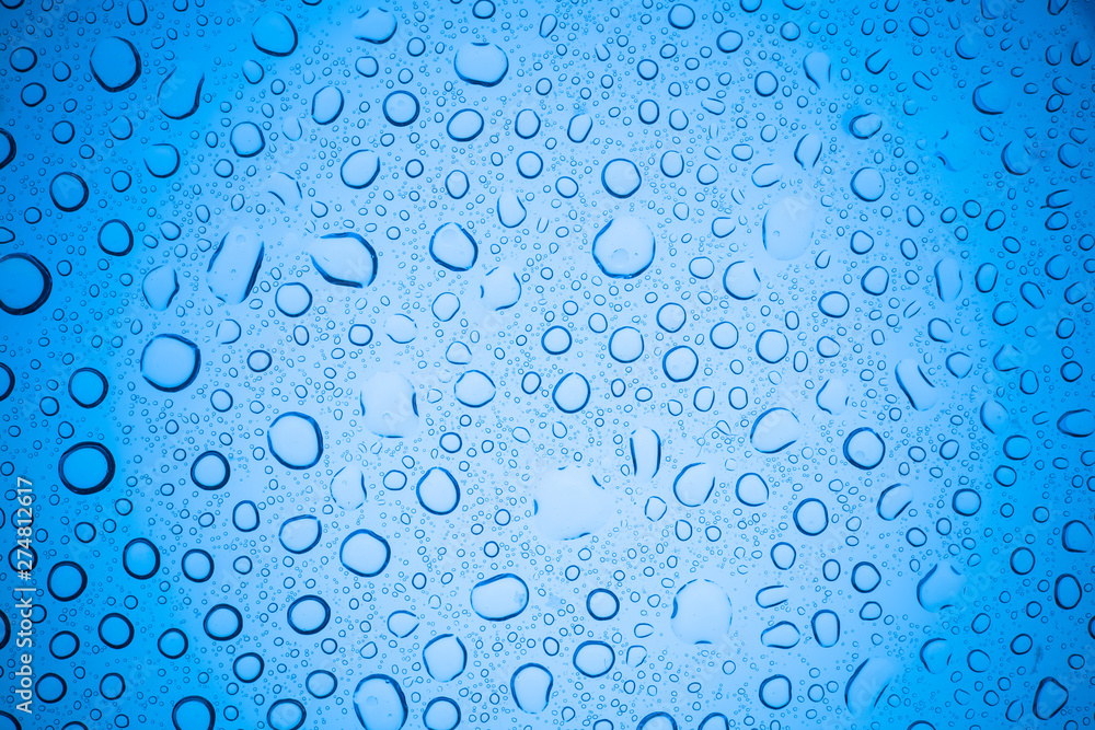 Rain droplets on blue glass background, Water drops on glass.