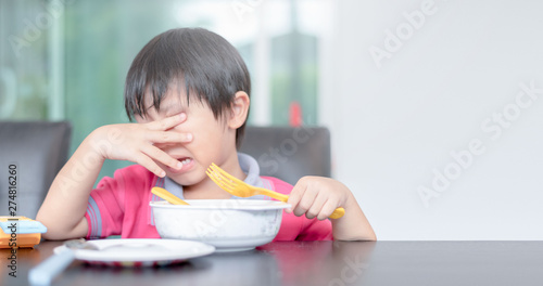 asian child boy eating boring food in morning