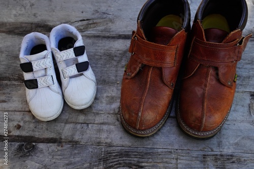 Daddy's boots and baby's shoes, fathers day concept © Shubby Studio