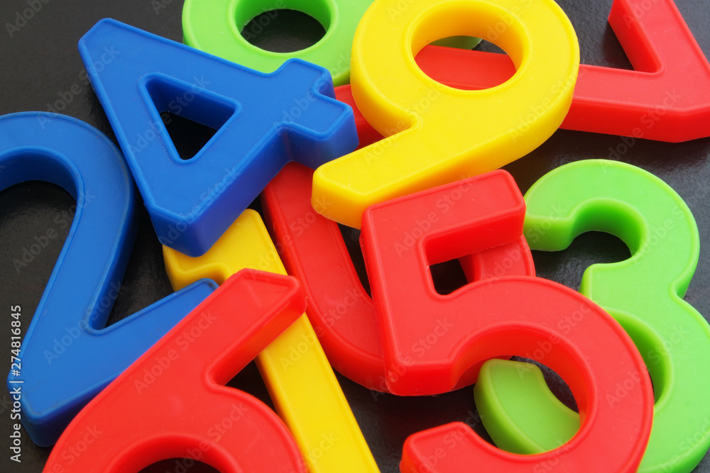Colorful plastic numbers on dark table Colorful plastic numbers on dark table