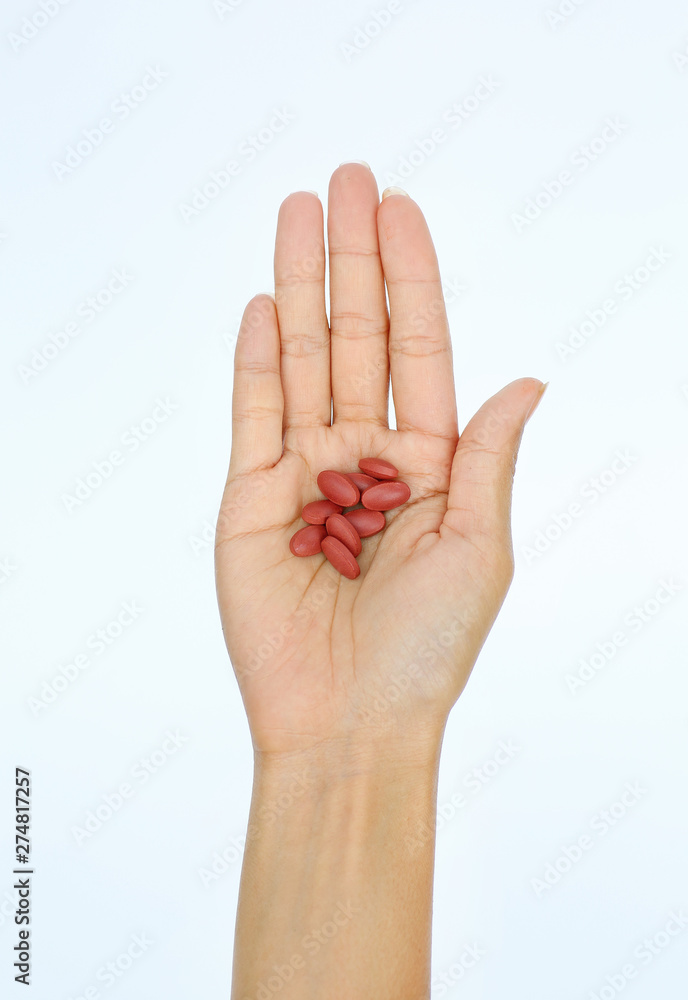 Close-up hand of a woman with some pills on white background Close-up hand of a woman with some pills on white background