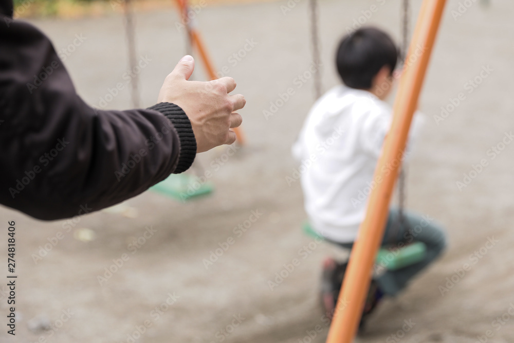 Obraz premium 公園の遊具で遊んでいる男の子の後ろから男性の手が伸びる不審者
