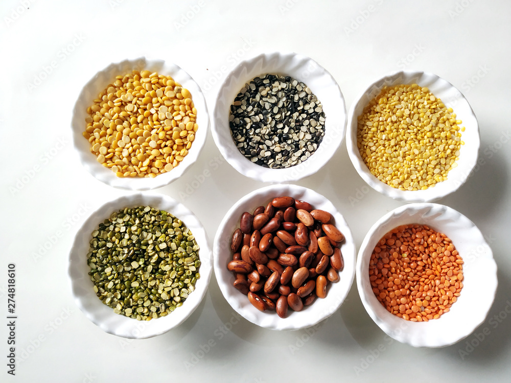 Uncooked pulses,grains and seeds in White bowls over white background. selective focus