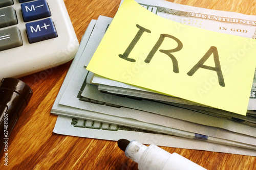 Tela IRA individual retirement account. Stack of money and calculator.