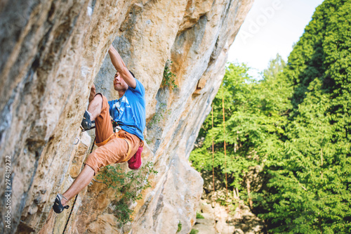 Man climbs rock.