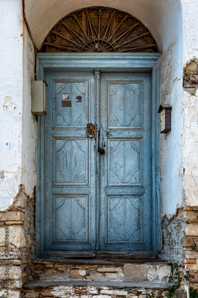 Old blue wooden door in opsharpanny building. Vertical.