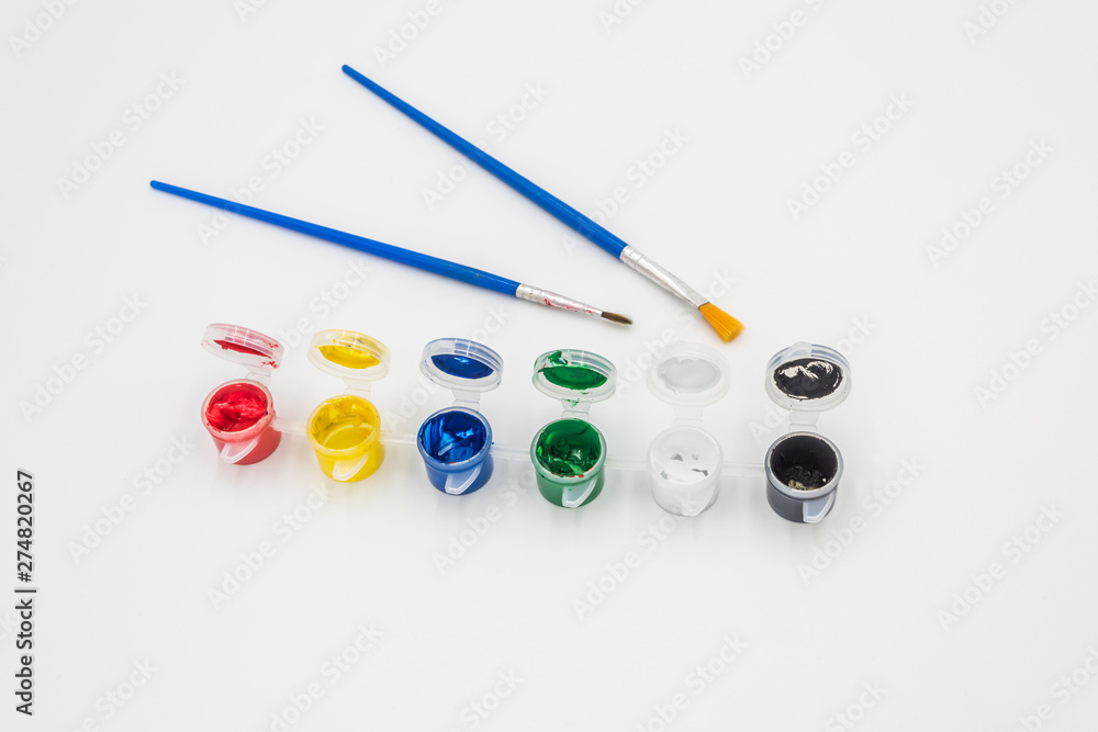 Colorful paints and brushes quietly placed on a white background Colorful paints and brushes quietly placed on a white background