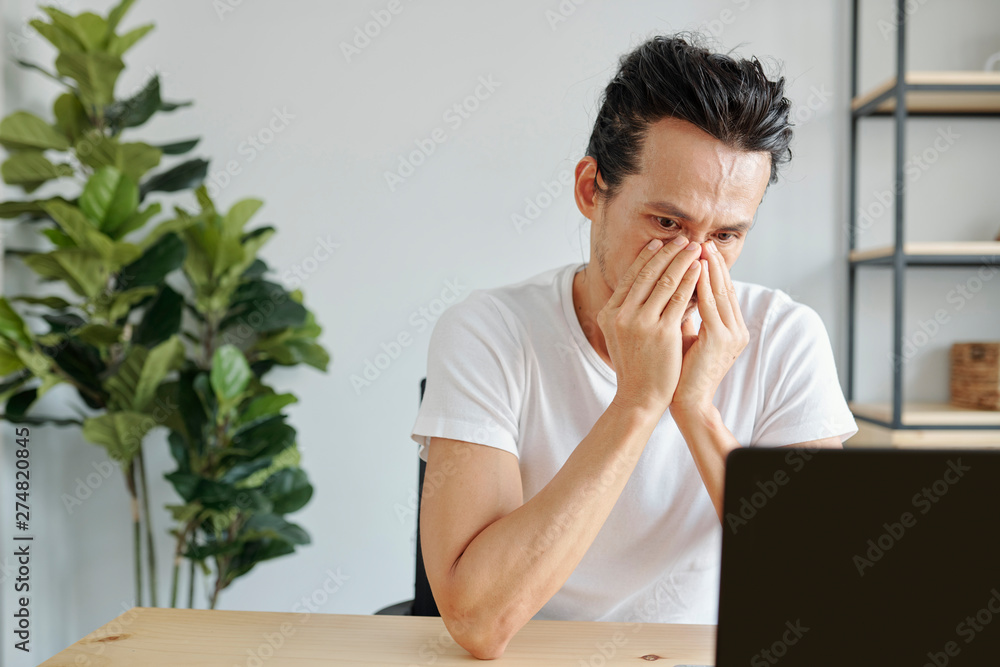 Portrait of almost crying Asian man reading e-mail with bad news on laptop  screen Stock-Foto | Adobe Stock