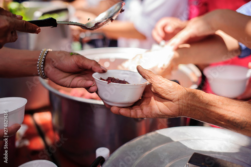 The hands of refugees have been aided by charity food to alleviate hunger : Feeding Concepts : Hand offered to donate food from a rich man Share : The concept of social sharing