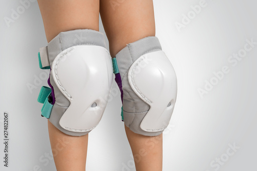 Pair of knee pads wearing on legs of child photo