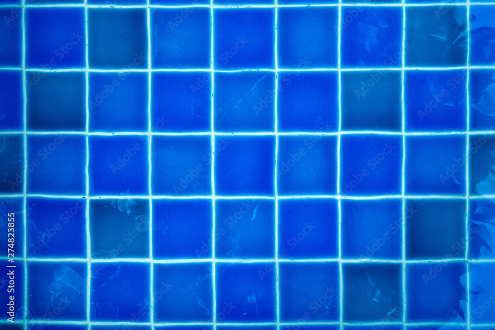 texture of Blue tiles of the swimming pool under clean water background
