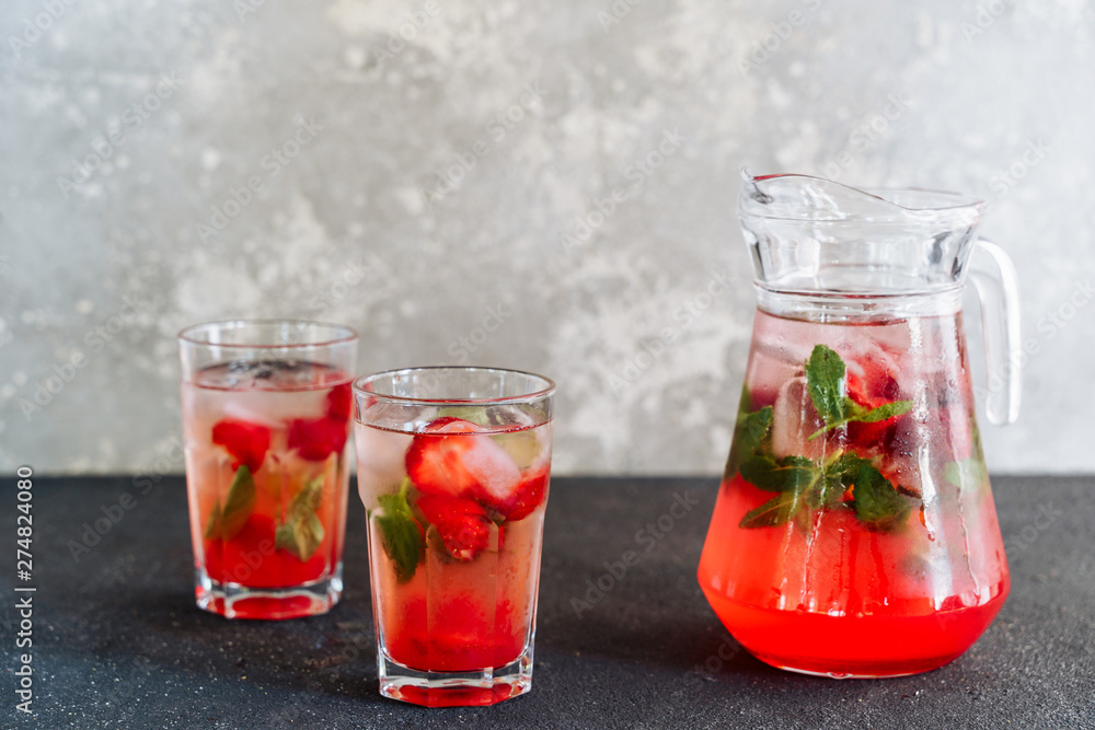 Glasses and Carafe with Fresh Strawberry Lemonade. Cold Refreshing Mixed Berries with Herbal Mint and Ice Beverage Cocktail in Cup and Decanter. Summer Juicy Vitamin Drink Side View Glasses and Carafe with Fresh Strawberry Lemonade. Cold Refreshing Mixed Berries with Herbal Mint and Ice Beverage Cocktail in Cup and Decanter. Summer Juicy Vitamin Drink Side View