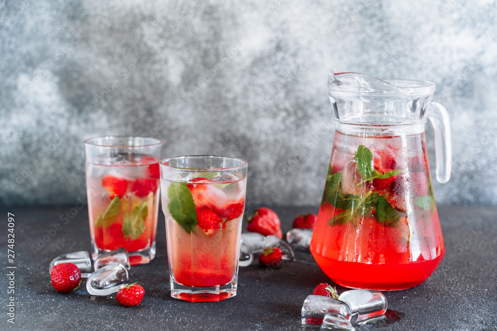 Glasses and Carafe with Fresh Strawberry Drink. Cold Refreshing Beverage Mixed with Herbal Mint Cocktail in Cup. Ice Cube and Ripe Berry Around of Flask. Summer Juicy Vitamin Water Side View Glasses and Carafe with Fresh Strawberry Drink. Cold Refreshing Beverage Mixed with Herbal Mint Cocktail in Cup. Ice Cube and Ripe Berry Around of Flask. Summer Juicy Vitamin Water Side View
