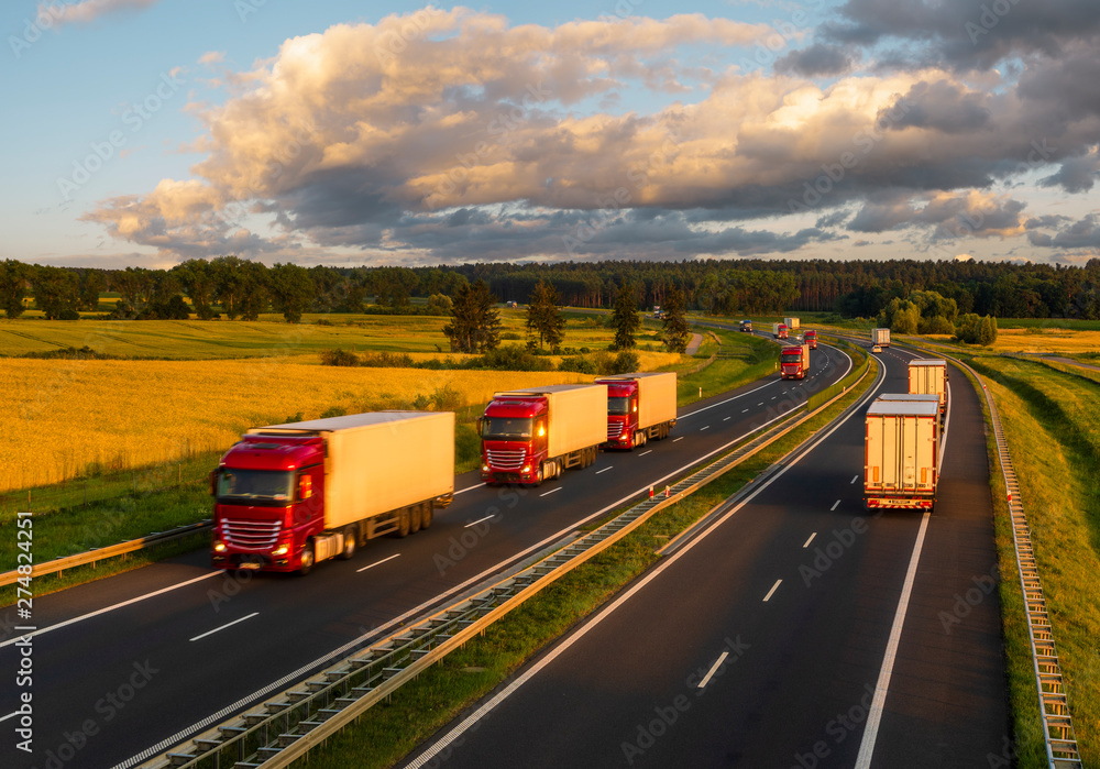 intensive highway traffic at sunset - column of trucks on the motorway in Poland
