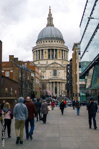 Saint Pauls cathedral in London with people in the foreground seen from the Millennium Bridge in winter day, UK