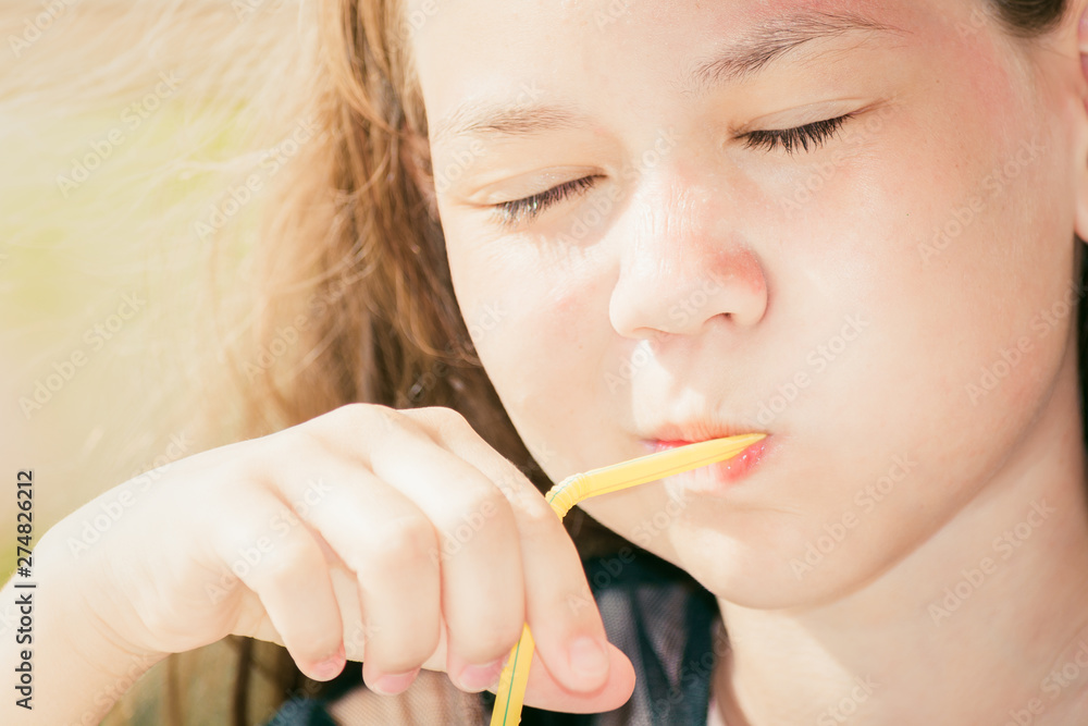 Beautiful girl with closed eyes drinking juice through straw on sunny day. Beautiful girl with closed eyes drinking juice through straw on sunny day.