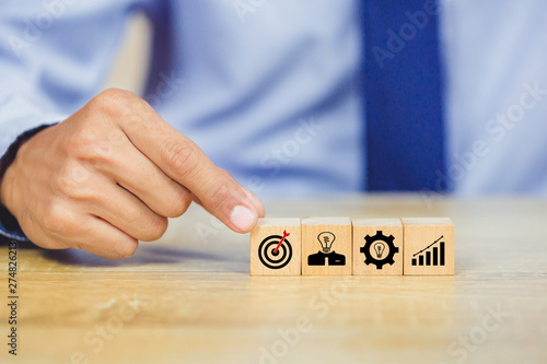 Hand of busines hold a target with arrow,stacking wooden blocks into steps,Concept of business growth success