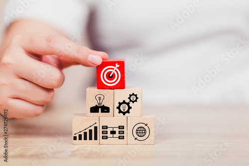 Hand of busines hold a target with arrow,stacking wooden blocks into steps,Concept of business growth success