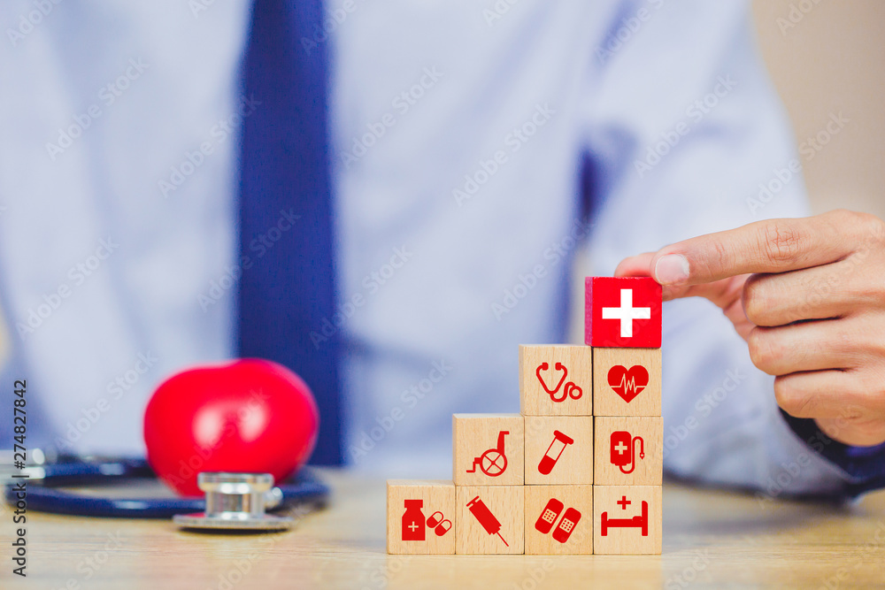 Health Insurance Concept,hand arranging wood block stacking with icon healthcare medical. Health Insurance Concept,hand arranging wood block stacking with icon healthcare medical.