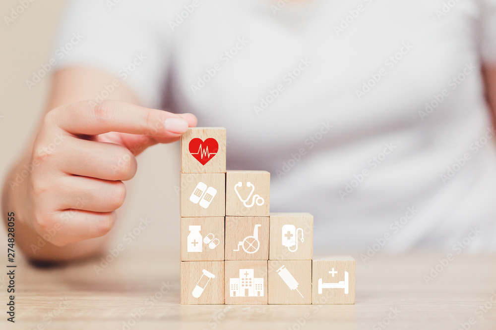 Health Insurance Concept,hand arranging wood block stacking with icon healthcare medical. Health Insurance Concept,hand arranging wood block stacking with icon healthcare medical.