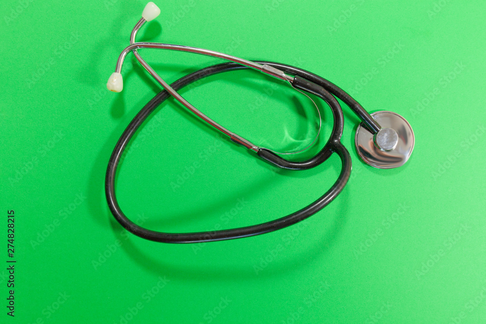A stethoscope connected to a phone laying on a pink and blue surface A stethoscope connected to a phone laying on a pink and blue surface