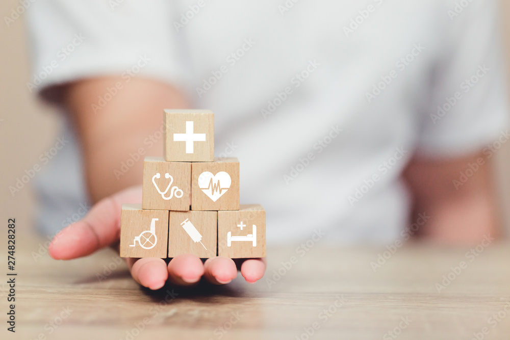 Health Insurance Concept,hand arranging wood block stacking with icon healthcare medical. Health Insurance Concept,hand arranging wood block stacking with icon healthcare medical.
