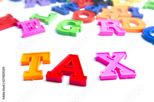 Heap of plastic colored alphabet letters close up. Tax