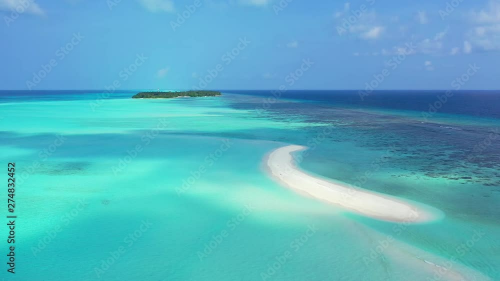 Aerial view of s-shaped sandbank surrounded by turquoise water. An island in the distance. In the Maldives. Aerial view of s-shaped sandbank surrounded by turquoise water. An island in the distance. In the Maldives.