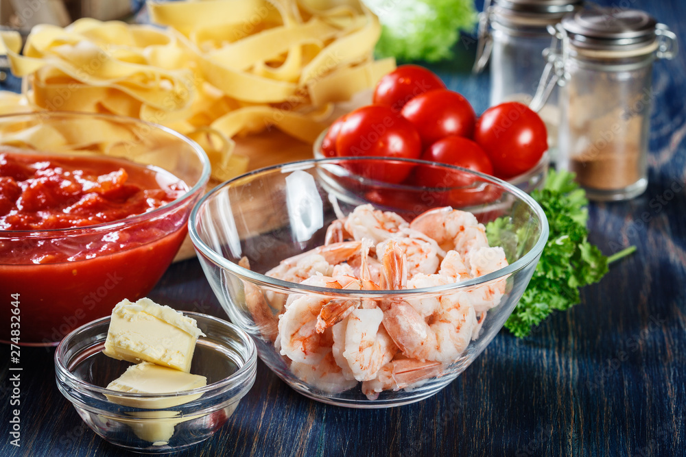 Ingredients ready for preparing pappardelle pasta with shrimp, tomatoes and herbs