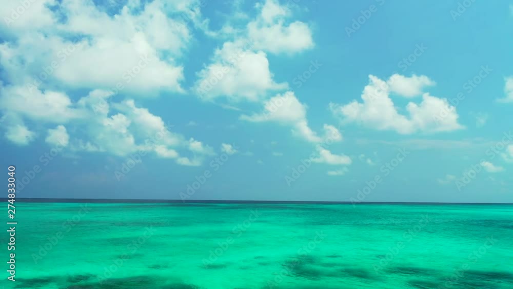 Aerial the turquoise sea with some reefs in it. A blue sky with some clouds above the Philippines. Dolly in with pan right. Aerial the turquoise sea with some reefs in it. A blue sky with some clouds above the Philippines. Dolly in with pan right.