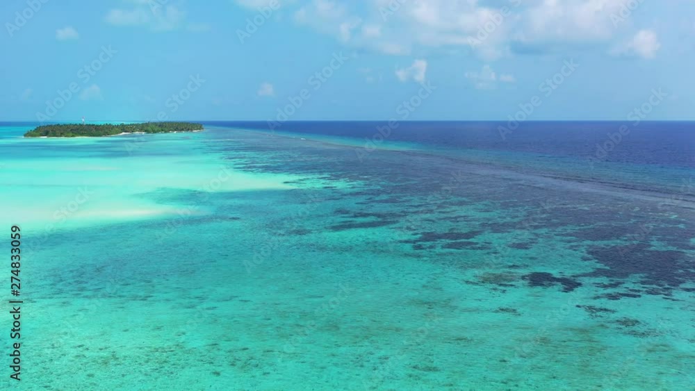 Aerial view, flight over turquoise water that turns into blue, an island in the distance. Reefs are visible in the sea in Jamaica. Pedestal up Aerial view, flight over turquoise water that turns into blue, an island in the distance. Reefs are visible in the sea in Jamaica. Pedestal up