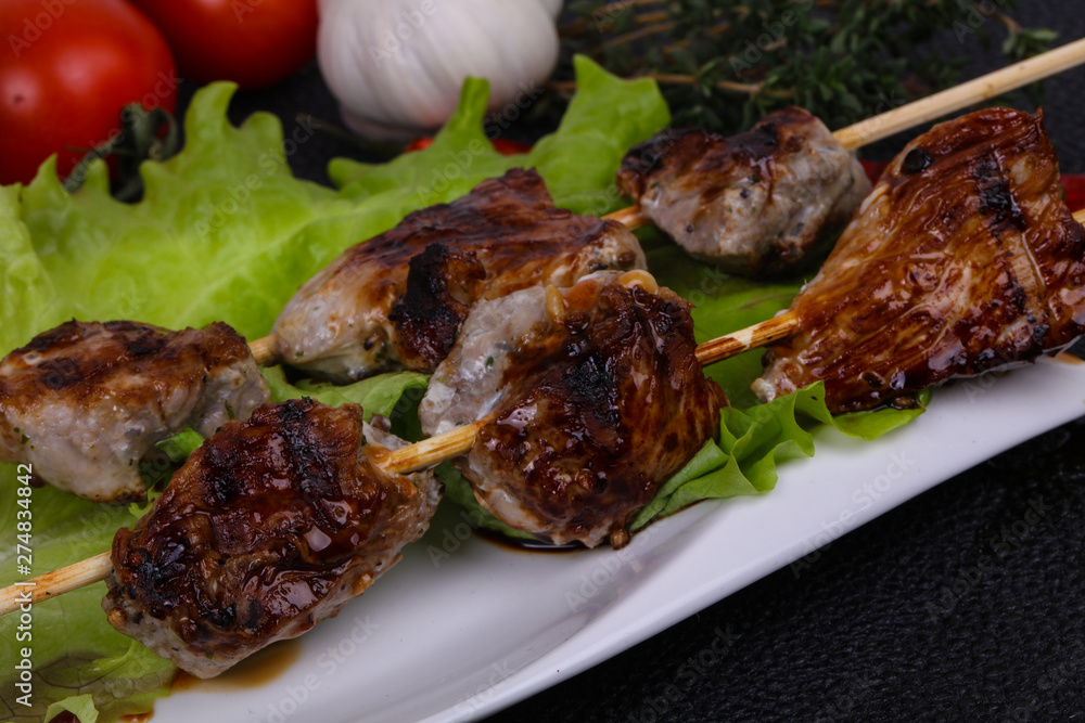 Pork kebab skewers in the plate with salad leaves and tomatoes