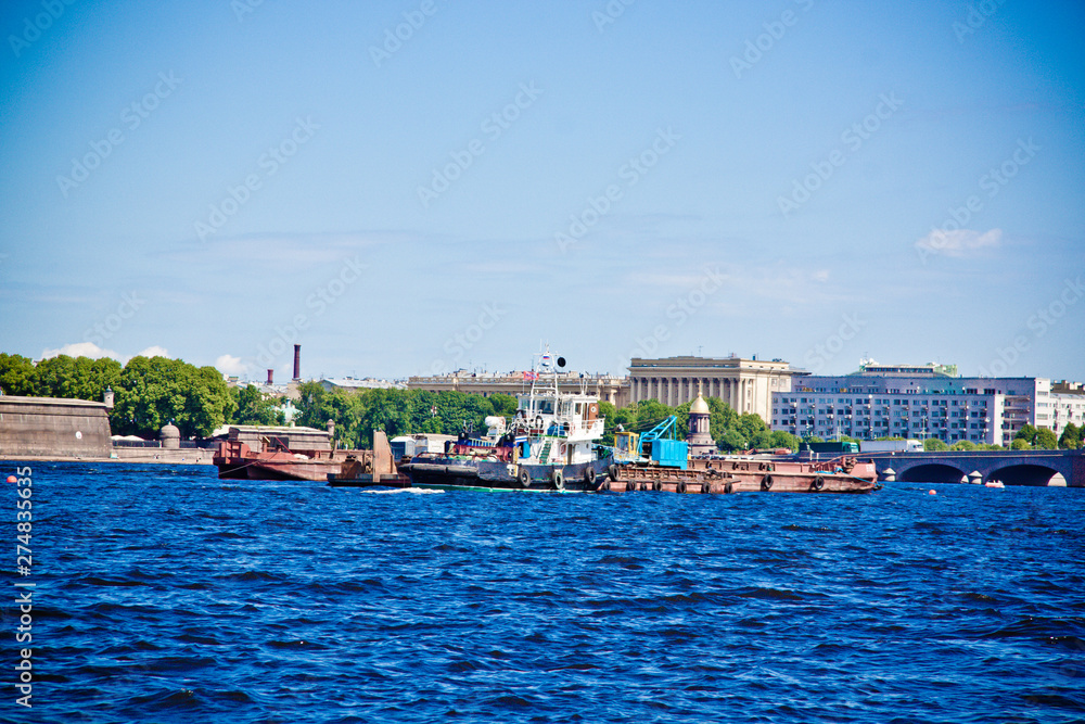 pleasure boat sails between houses under the bridge