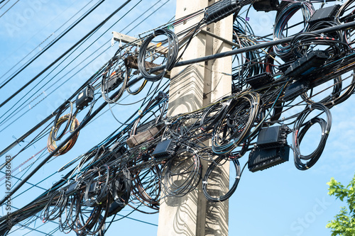 Messy electrical cables in thailand - many lines of cables chaotic set of interwoven, optical fiber technology open air outdoors.
