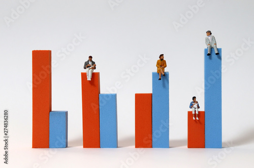 Miniature people sitting on a bar graph. The concept of population change. photo